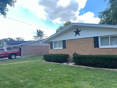 A brick ranch with a clean, cleared front lawn at the end of the job.